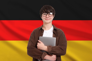 Image of Student with eyeglasses and laptop against flag of Germany. Language school