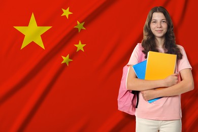 Image of Student with notebooks and backpack against flag of China. Language school