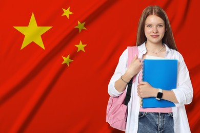Image of Student with notebook and backpack against flag of China. Language school