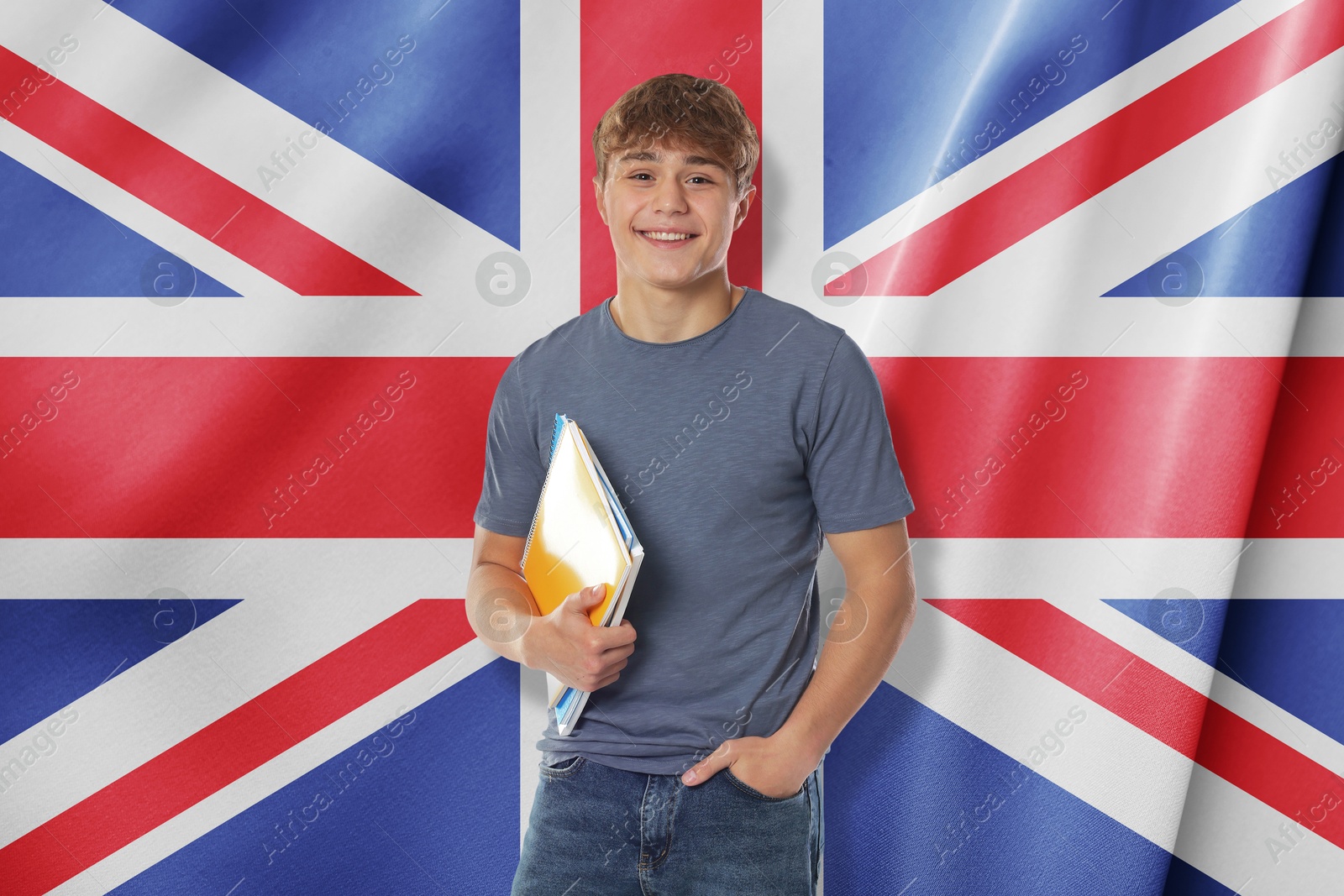 Image of Happy student with notebooks against flag of United Kingdom. Language school