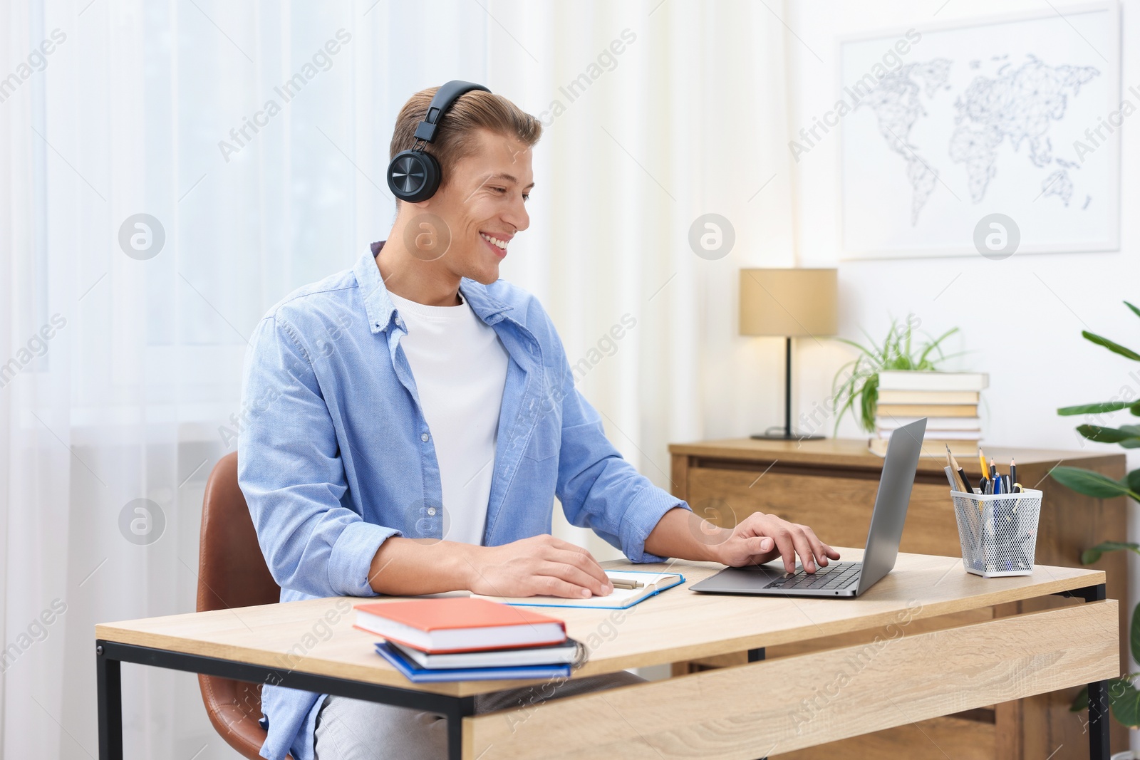 Photo of Man passing online test via laptop at table indoors