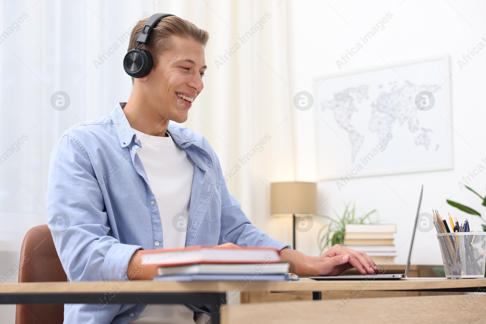 Photo of Man passing online test via laptop at table indoors