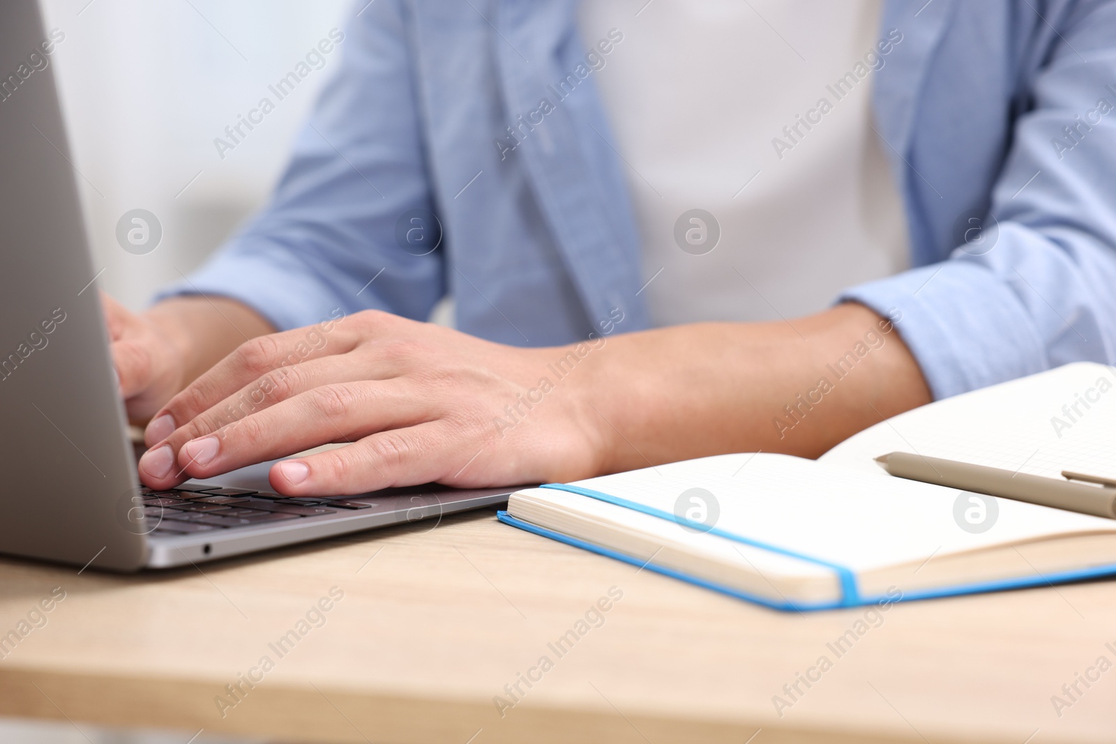 Photo of Man passing online test via laptop at table indoors, closeup