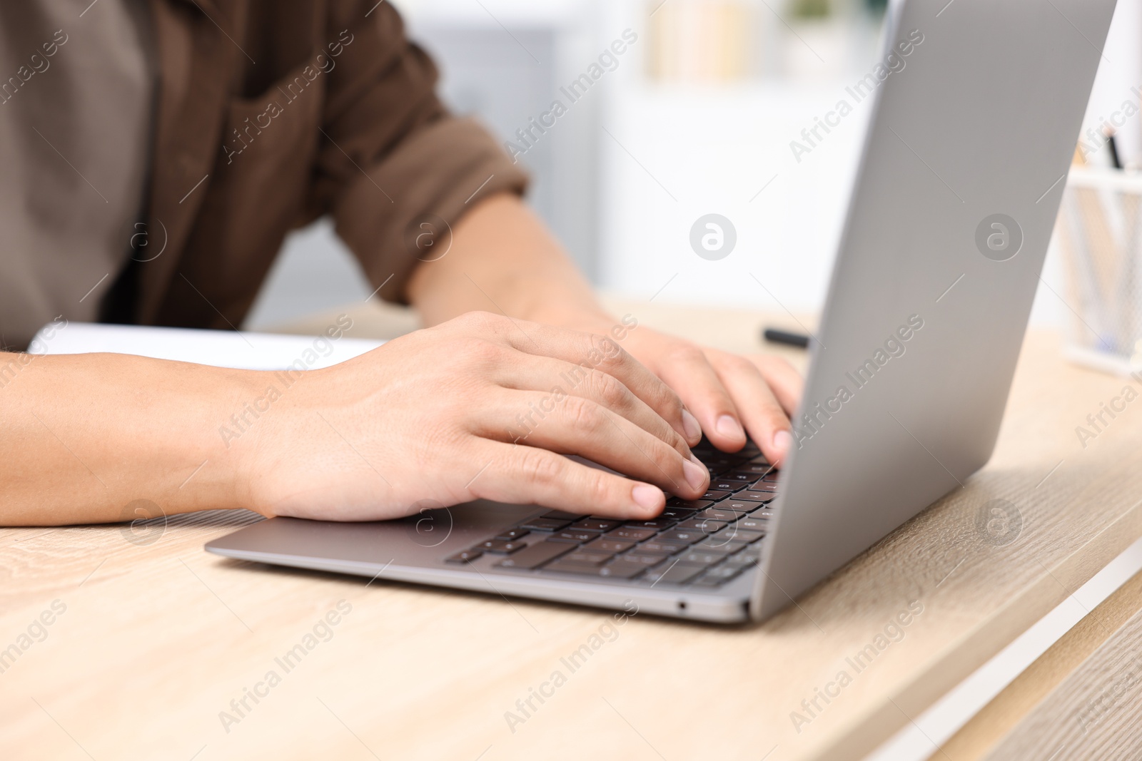 Photo of Man passing online test via laptop at table indoors, closeup