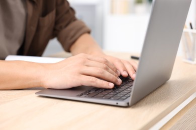 Photo of Man passing online test via laptop at table indoors, closeup
