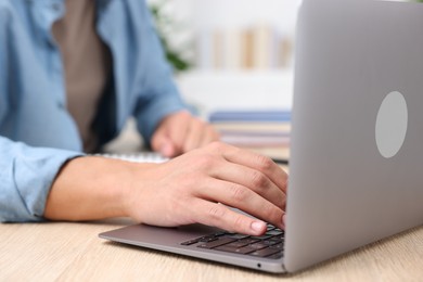Photo of Man passing online test via laptop at table indoors, closeup