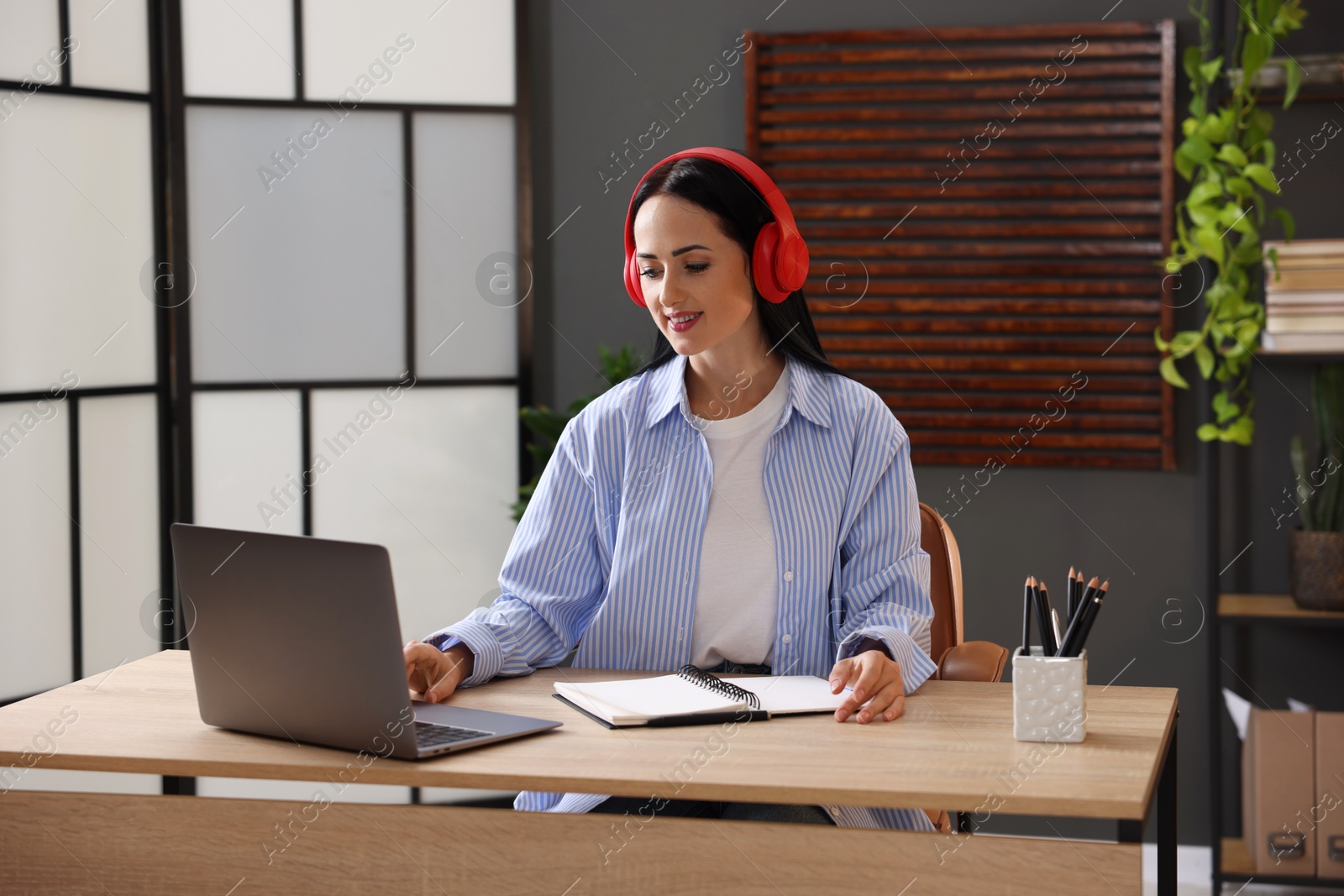 Photo of Woman passing online test via laptop at table indoors