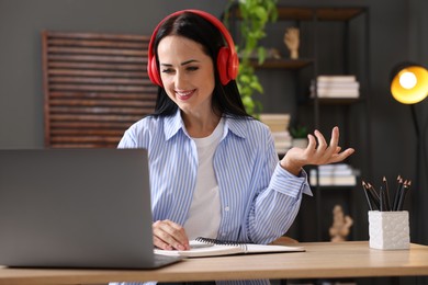 Photo of Woman passing online test via laptop at table indoors