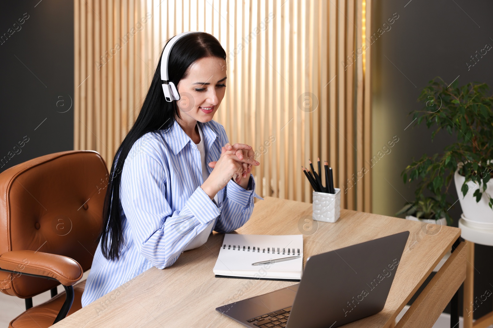 Photo of Woman passing online test via laptop at table indoors
