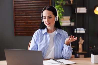 Photo of Woman passing online test via laptop at table indoors