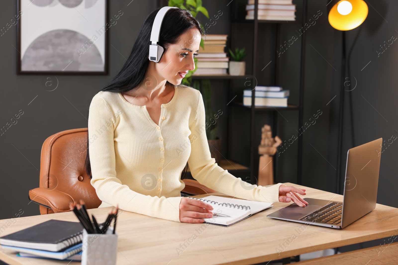 Photo of Woman passing online test via laptop at table indoors