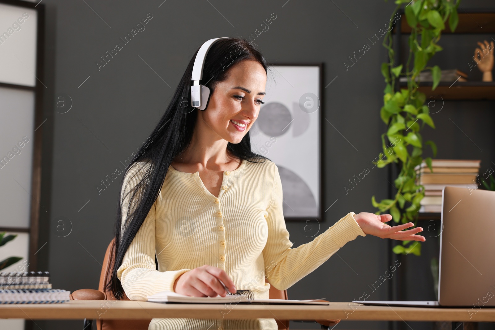 Photo of Woman passing online test via laptop at table indoors