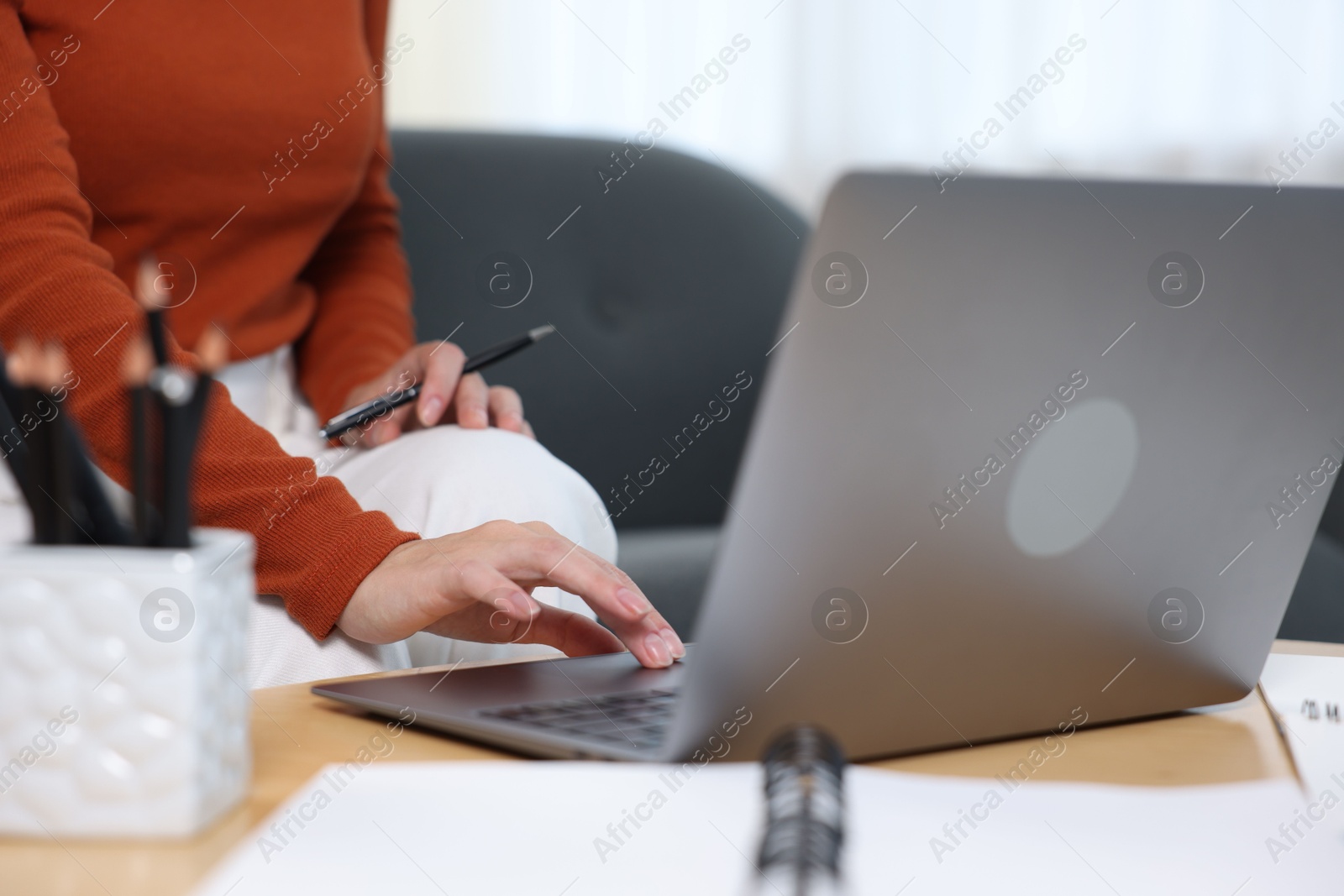 Photo of Woman passing online test on laptop at home, closeup