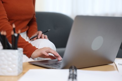 Photo of Woman passing online test on laptop at home, closeup