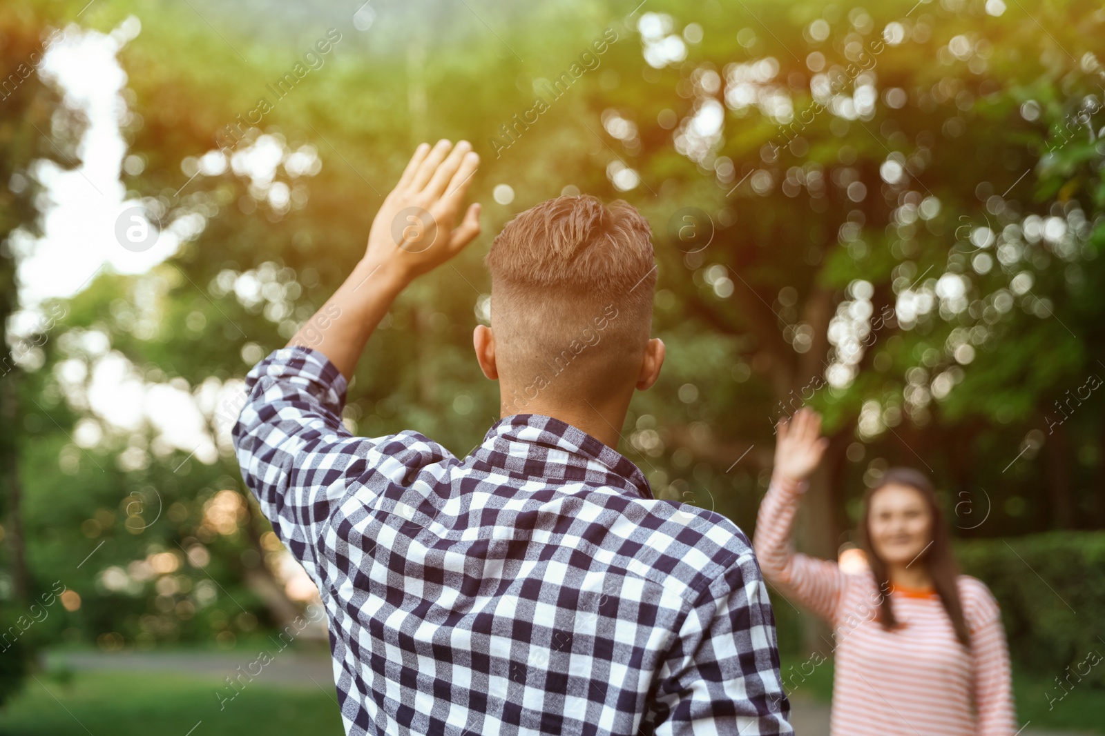 Photo of Woman waving goodbye to her friend in park, selective focus