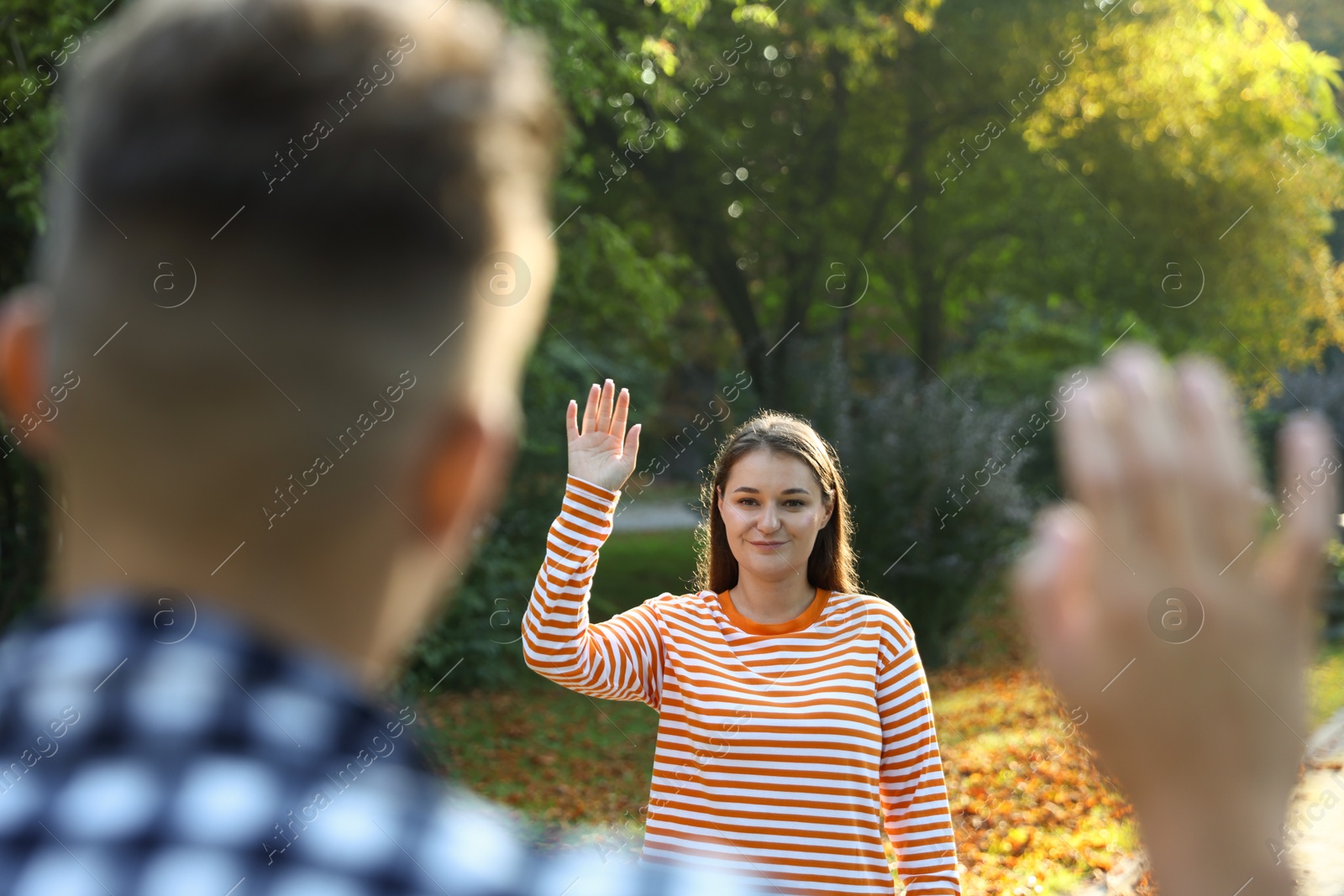 Photo of Man waving goodbye to his friend in park, selective focus