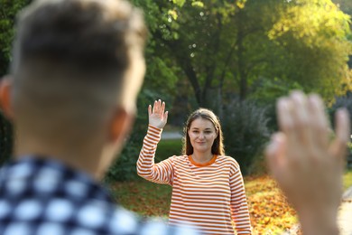 Photo of Man waving goodbye to his friend in park, selective focus