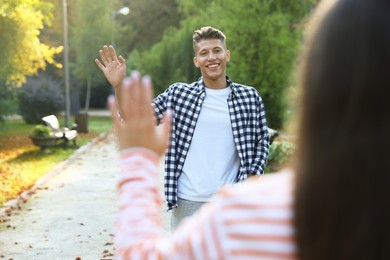 Photo of Man waving goodbye to his friend in park, selective focus