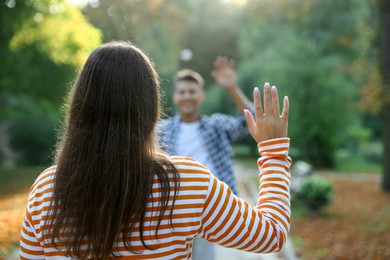 Photo of Man waving goodbye to his friend in park, selective focus