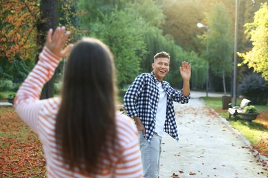 Photo of Woman waving goodbye to her friend in park, selective focus