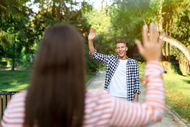 Photo of Woman waving goodbye to her friend in park, selective focus