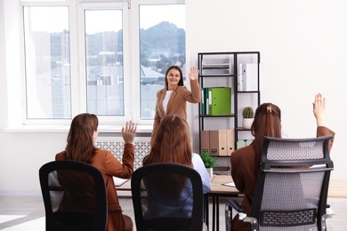 Photo of Woman waving goodbye to her colleagues in office