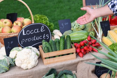 Photo of Man choosing fresh vegetables from stall at farmer's market, closeup