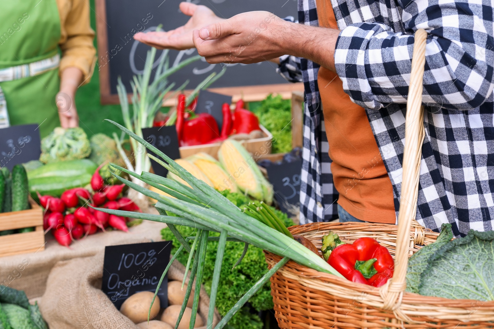 Photo of Man choosing fresh vegetables from stall at farmer's market, closeup