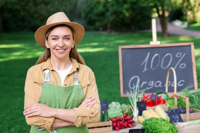 Photo of Happy farmer near stall with different fresh vegetables at market