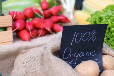 Photo of Many different vegetables and 100% Organic sign on stall at farmer's market, closeup