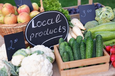 Photo of Many different vegetables and Local Products sign on stall at farmer's market, closeup