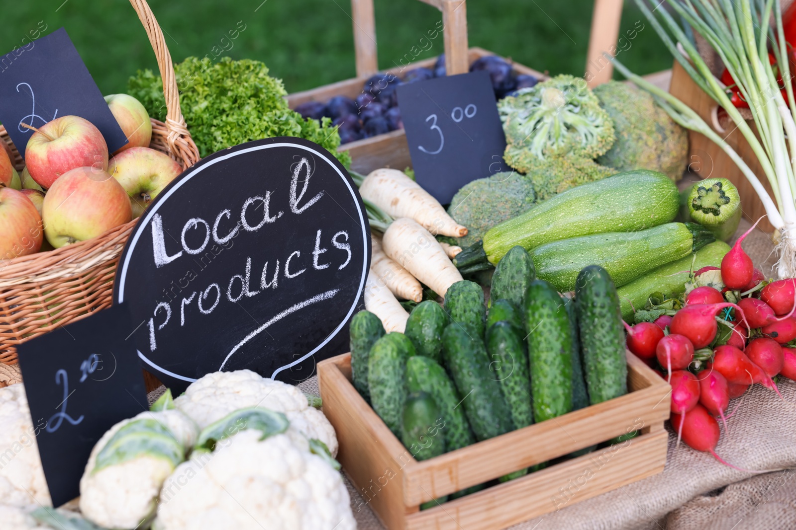 Photo of Many different vegetables and Local Products sign on stall at farmer's market, closeup