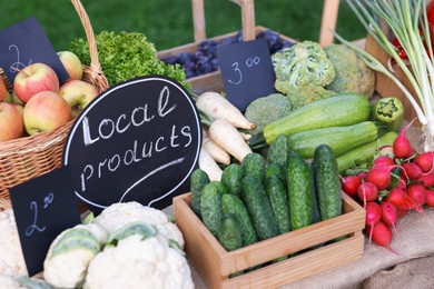 Photo of Many different vegetables and Local Products sign on stall at farmer's market, closeup