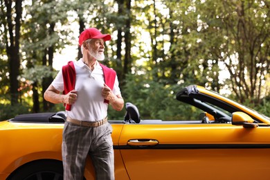 Photo of Stylish senior man near modern cabriolet outdoors