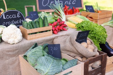 Photo of Many different vegetables and Local Products sign on stall at farmer's market, closeup