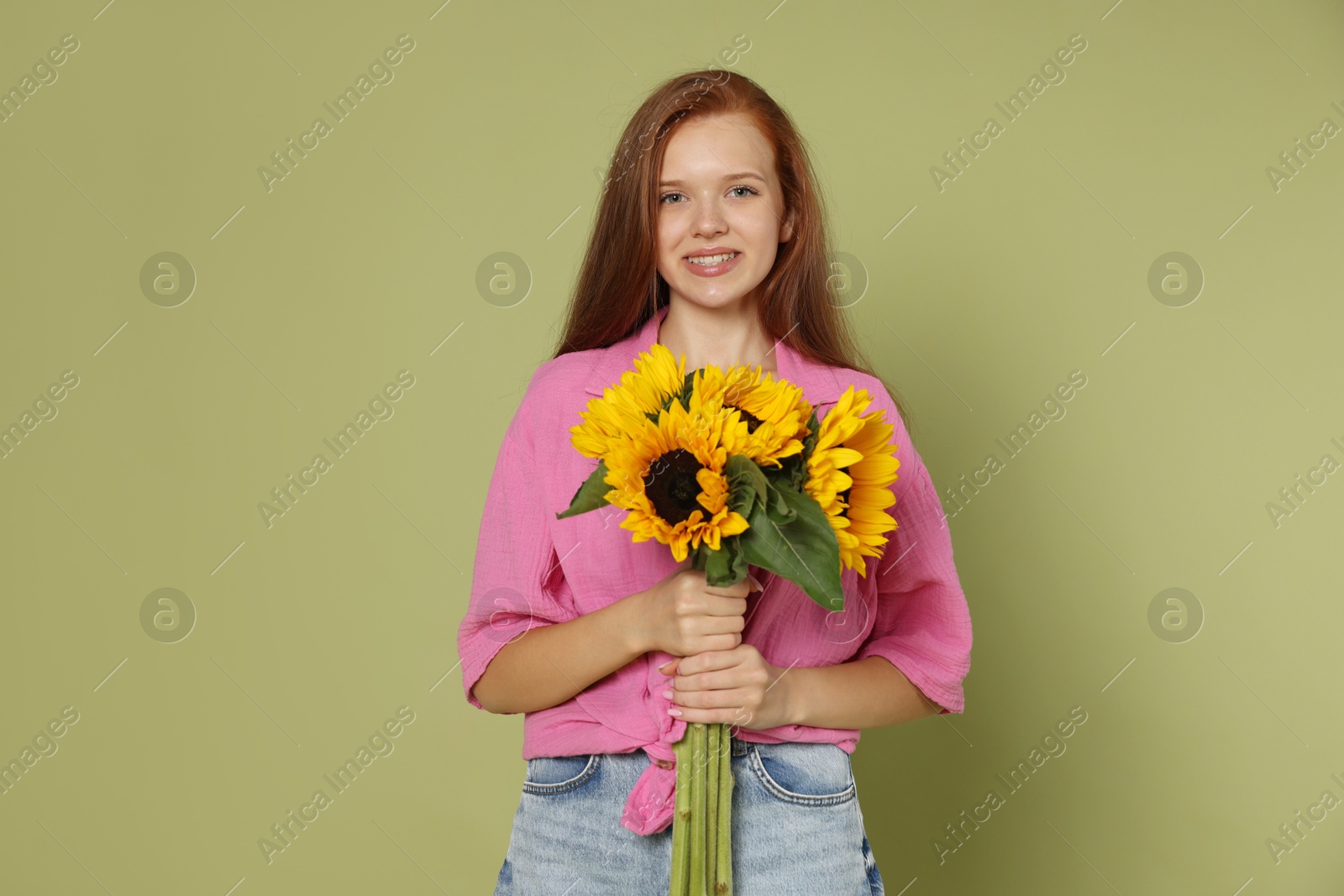 Photo of Teenage girl with bouquet of beautiful sunflowers on green background