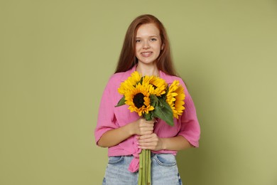 Photo of Teenage girl with bouquet of beautiful sunflowers on green background