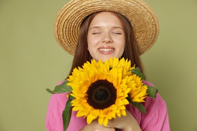 Photo of Teenage girl with beautiful sunflowers on green background