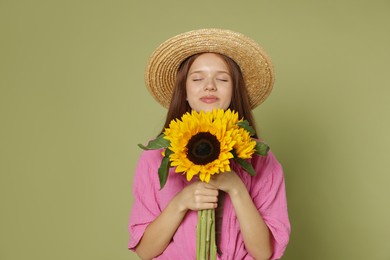 Photo of Teenage girl with beautiful sunflowers on green background