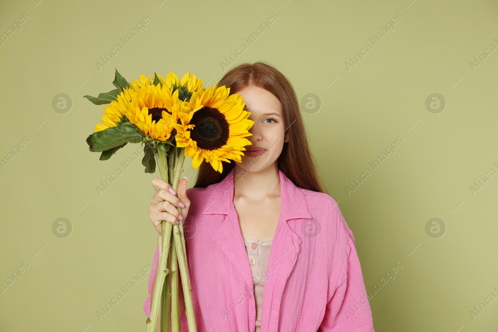 Photo of Teenage girl with beautiful sunflowers on green background