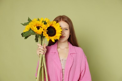 Photo of Teenage girl with beautiful sunflowers on green background