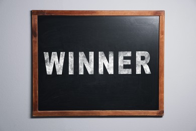 Image of Chalkboard with word Winner hanging on white wall