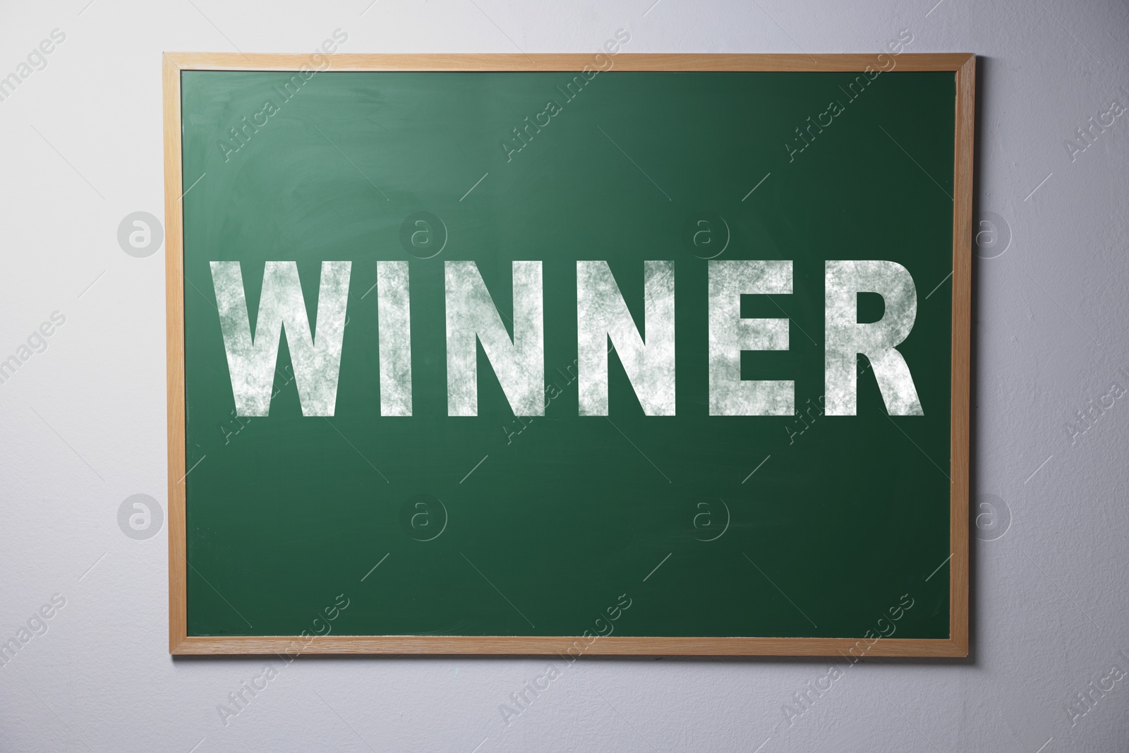 Image of Chalkboard with word Winner hanging on grey wall