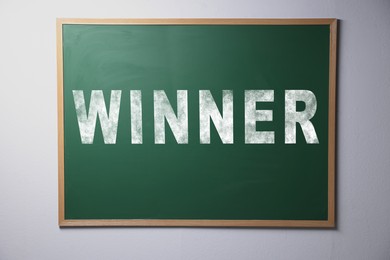Image of Chalkboard with word Winner hanging on grey wall