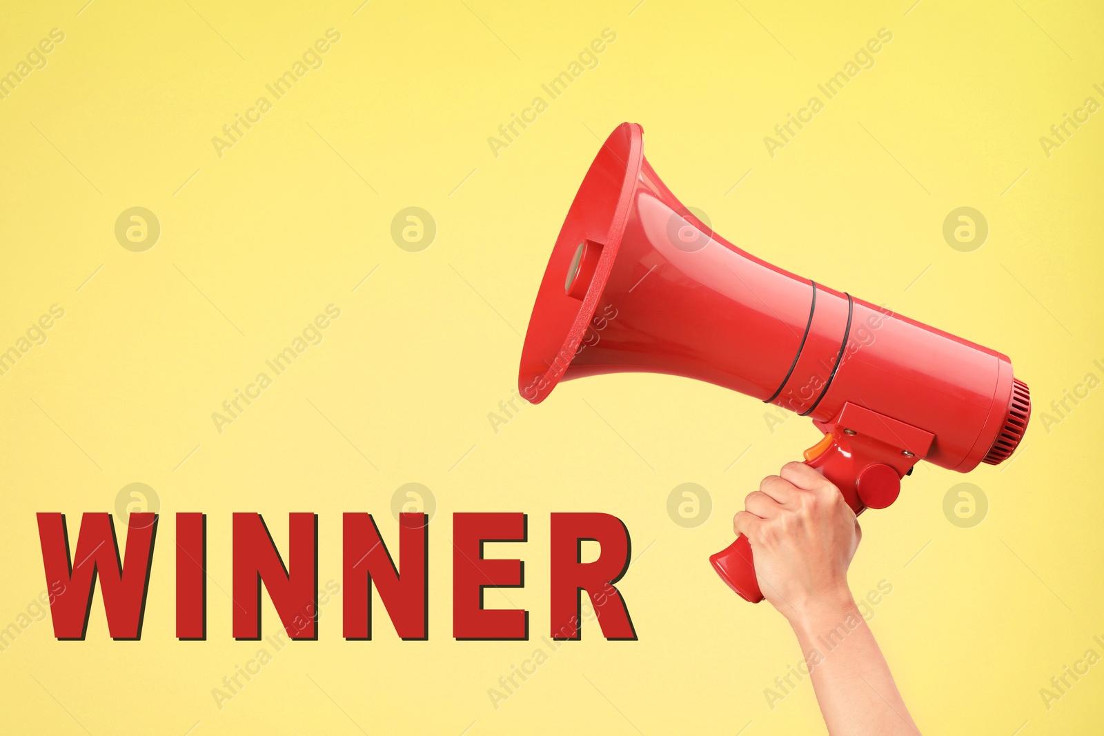 Image of Winner. Woman holding red loudspeaker against yellow background, closeup