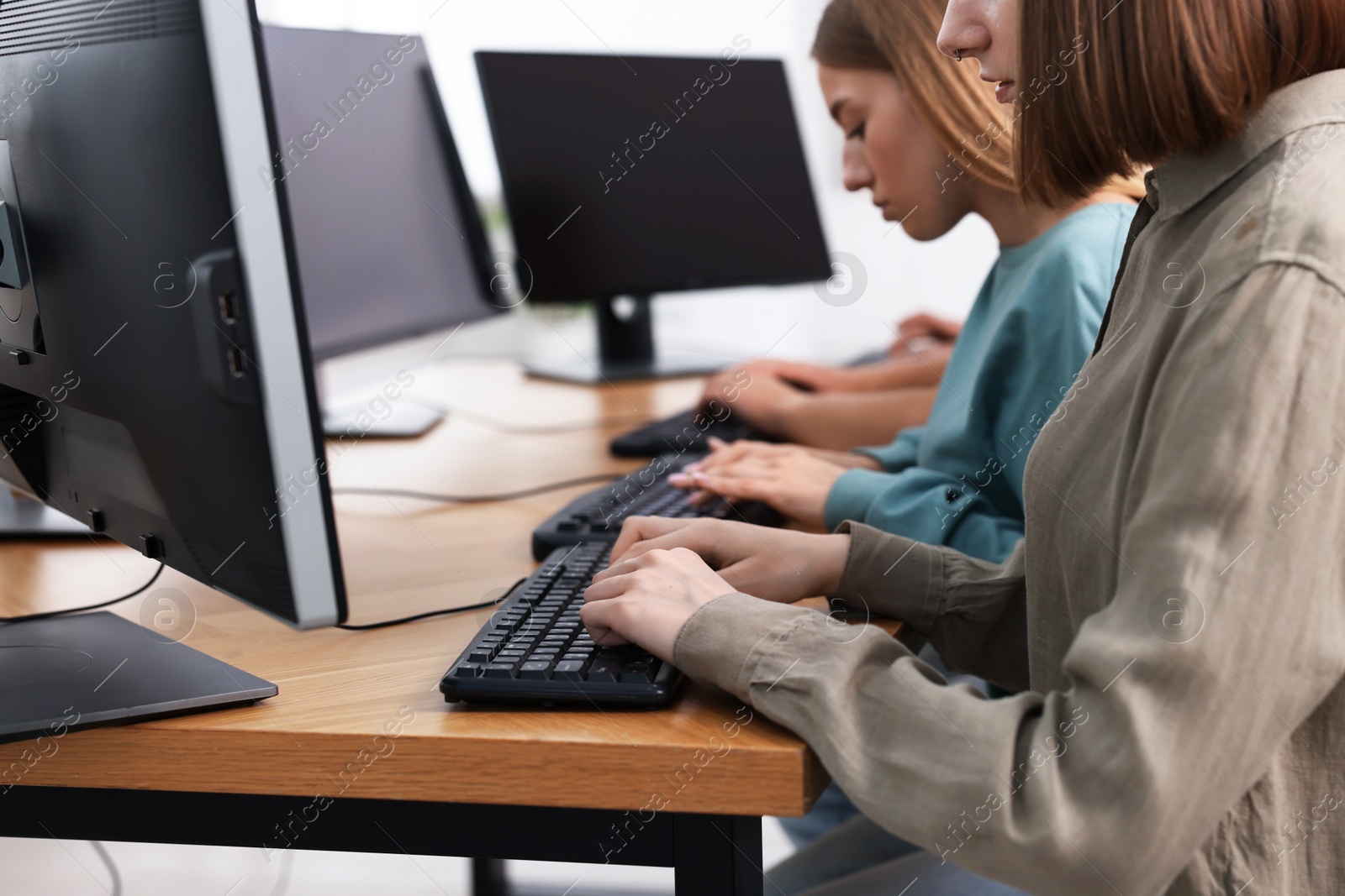 Photo of Students taking online exam indoors, selective focus