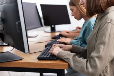 Photo of Students taking online exam indoors, selective focus