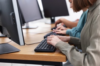 Photo of Students taking online exam indoors, selective focus
