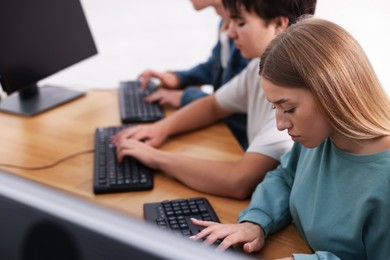 Photo of Students taking online exam indoors, selective focus