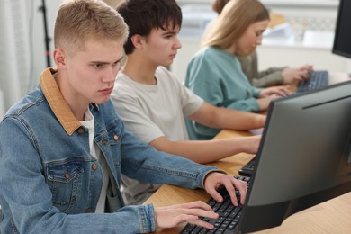 Photo of Students taking online exam indoors, selective focus